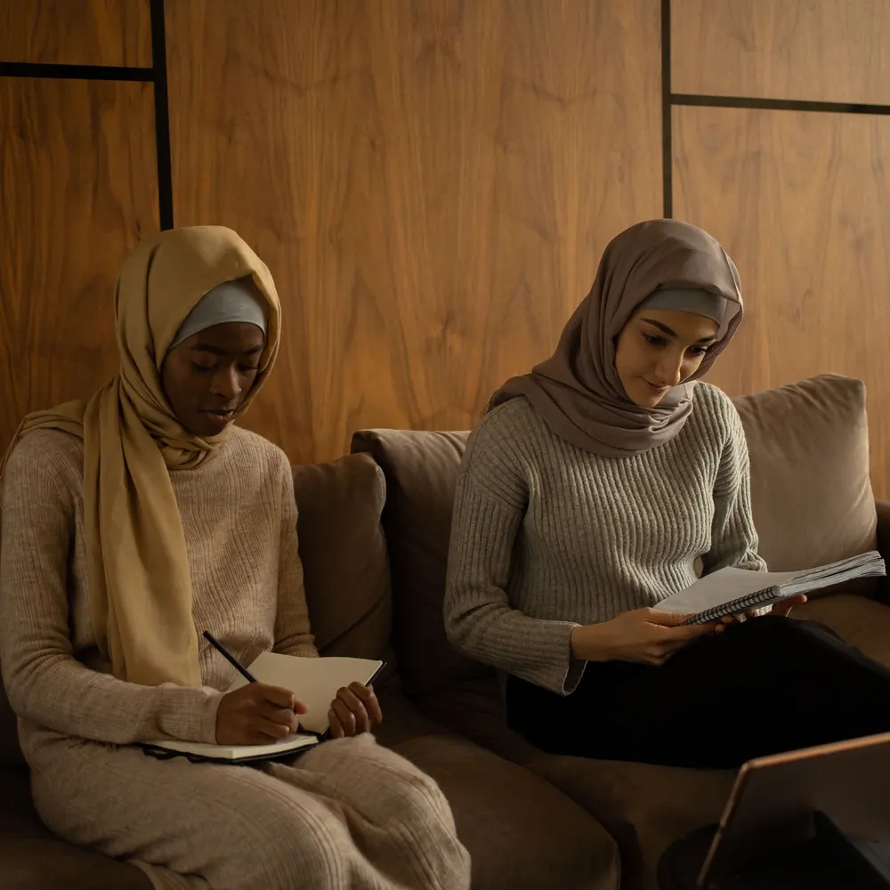 Deux femmes étudient côte à côte, carnet à la main